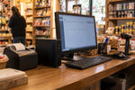 Mini PC empresarial instalado junto a un monitor en el mesón de caja de una tienda